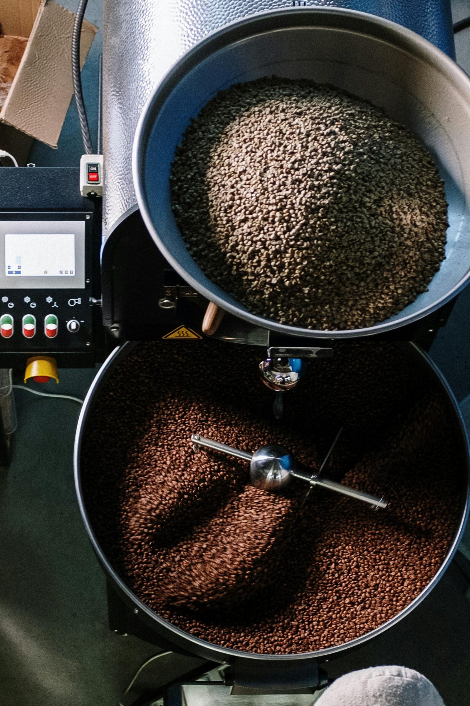 Services Top view of a coffee roasting machine processing beans in a workshop.